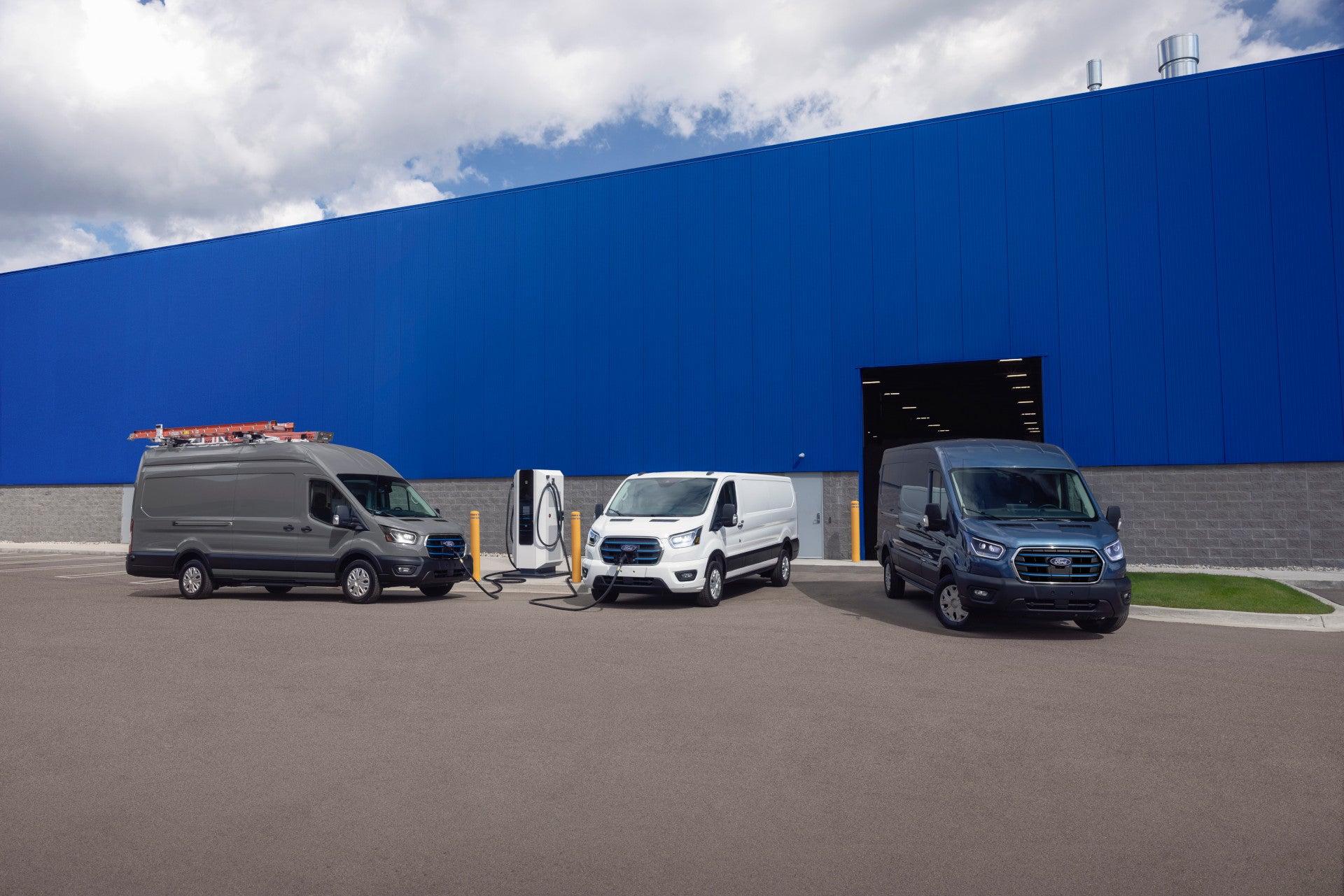 Multiple Ford Transits parked outside a building